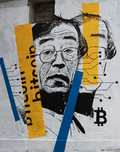 Black-and-white street mural of a man's face in glasses, with yellow and blue stripes, the word bitcoin and circuit lines.